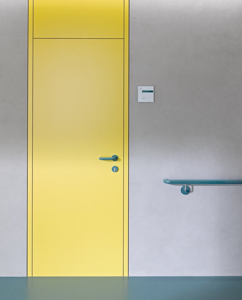 HEWI Türdrücker & Handlauf Gelbe Tür ausgestattet mit Türdrücker System 111 in Aquablau, Handlauf in Aquablau
