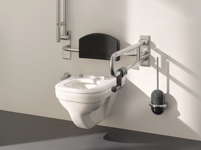 Barrier-free WC in public areas equipped with folding support handles, backrest and toilet brush